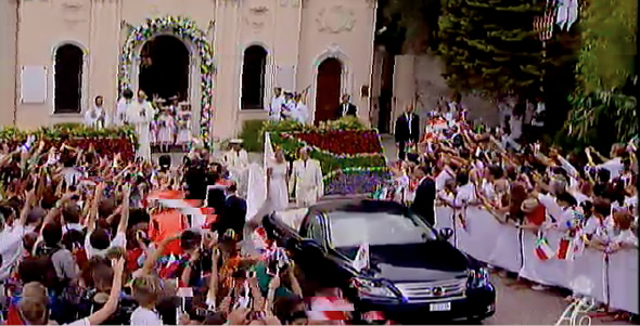 Charlene and Prince Albert outside the Chapel of St. Devota with South African flowerbed behind