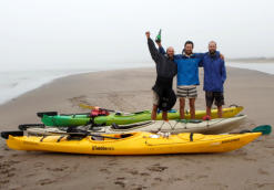 Raising a bottle of champagne at Alexander Bay, the end of the journey.