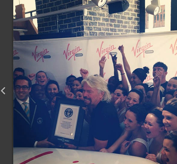 Mini Cooper surrounded by ladies and Branson