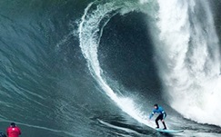 South African big wave superstar Grant "Twiggy" Baker is dwarfed by a monster wave on his way to capturing the 2014 Mavericks Invitational title (Photo: Grant Ellis, Surfer Mag) 