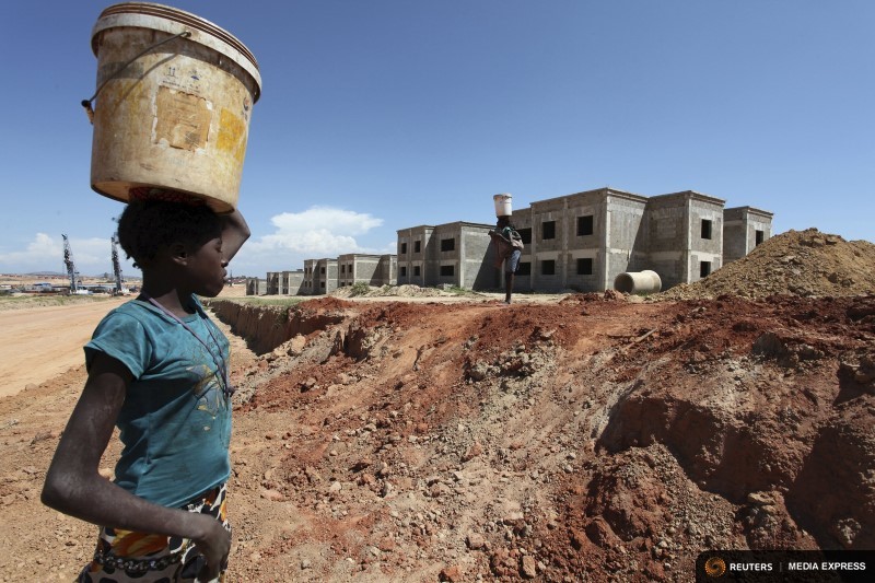 A woman walks past a Chinese construction site in Lubango africa-reuters