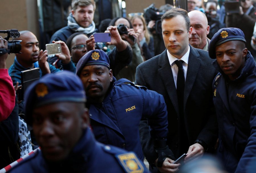 FILE PHOTO Paralympic gold medalist Oscar Pistorius is escorted by police officers as he arrives for his sentencing for the 2013 murder of his girlfriend Reeva Steenkamp, at Pretoria High Court, South Africa July 6, 2016. REUTERS/Siphiwe Sibeko/File Photo