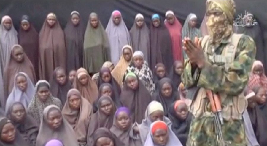 A still image from a video posted by Nigerian Islamist militant group Boko Haram on social media, seen by Reuters on August 14, 2016, shows a masked man talking to dozens of girls the group said are school girls kidnapped in the town of Chibok in 2014. Social Media