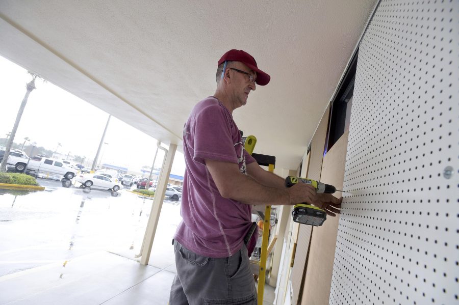 Elijah Nadr boards up the outside of Sunshine Liquor before the arrival of Hurricane Matthew in South Daytona, Florida, U.S., Oct. 6, 2016. REUTERS/Phelan Ebenhack
