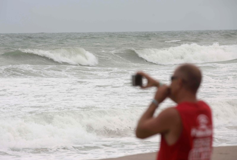 A man takes pictures of the waves while Hurricane Matthew approaches in Melbourne, Florida, U.S. October 6, 2016. REUTERS/Henry Romero
