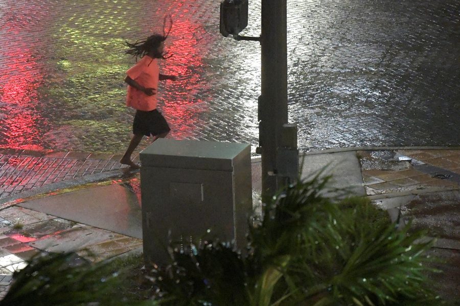 A pedestrian runs across a street as the eye of Hurricane Matthew approaches Daytona Beach, Florida, U.S. October 7, 2016. REUTERS/Phelan Ebenhack