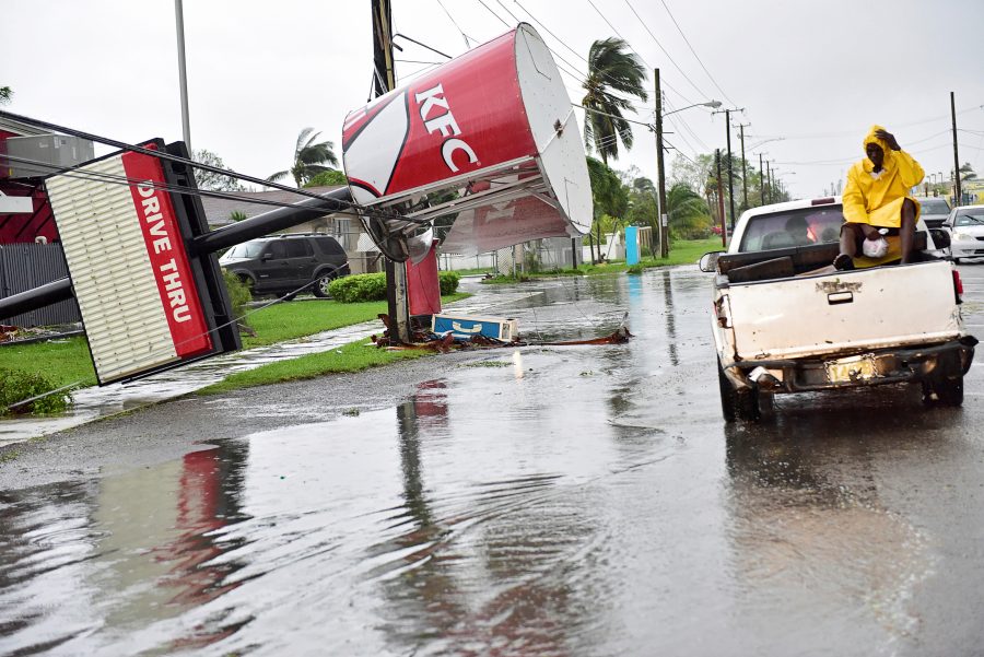A KFC sign damaged by Hurricane Matthew is supported by utility lines on Carmichael Road in Nassau, Bahamas October 6, 2016. REUTERS/Dante Carrer