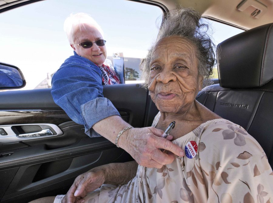 Grace Bell Hardison, a 100-year-old woman recently mentioned by President Barack Obama after attempts were made to purge her from the voter registration list and hence deny her right to vote, receives an "I Voted Today" sticker from election official Elaine Hudnell after she cast her ballot in the U.S. general election from a car in Belhaven, North Carolina, U.S. on November 8, 2016. REUTERS/Jonathan Drake