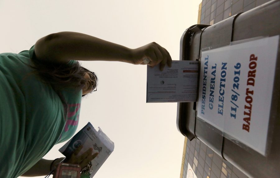 A woman drops her ballot during the presidential election at LA County Registrar Office in Norwalk, California, U.S., November 8, 2016. REUTERS/Mario Anzuoni