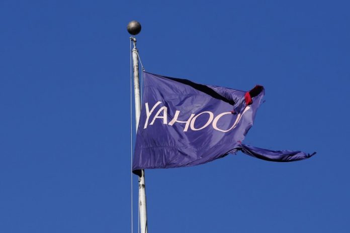 A tattered flag bearing the Yahoo company logo flies above a building in New York