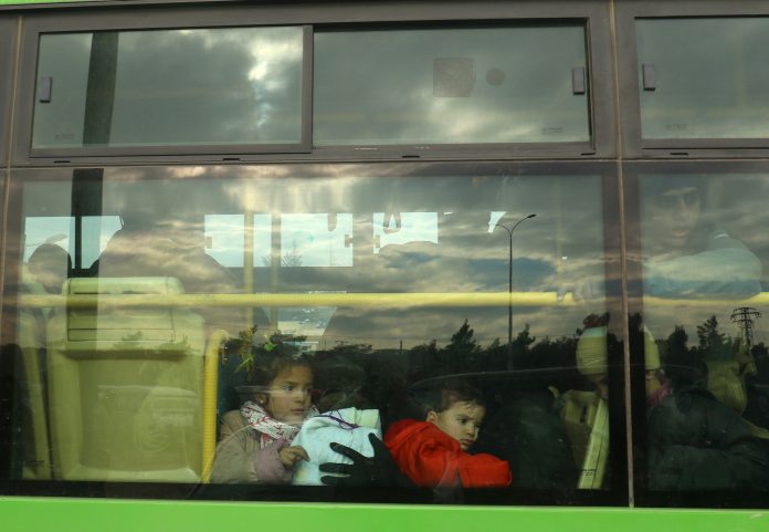 Evacuees from rebel-held eastern Aleppo arrive by bus to an area on the western edge of Aleppo city which is held by insurgents, in Syria
