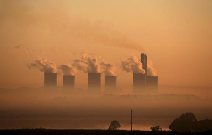 Steam rises at sunrise from the Lethabo Power Station, a coal-fired power station owned by state power utility ESKOM near Sasolburg