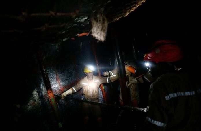 Mine workers employed at Sibanye Gold's Masimthembe shaft operate a drill in Westonaria