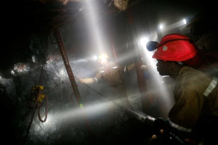 FILE PHOTO: Mine workers employed at Sibanye Gold's Masimthembe shaft operate a drill in Westonaria