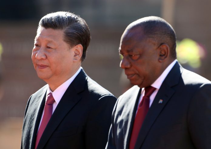 China's President Xi Jinping walks with South African President Cyril Ramaphosa before their meeting in Pretoria