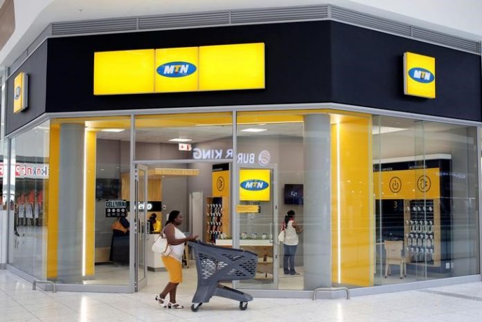 A shopper walks past an MTN shop at mall in Johannesburg