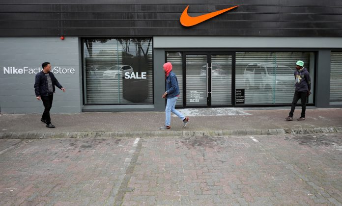 People walk past a closed Nike store in Cape Town