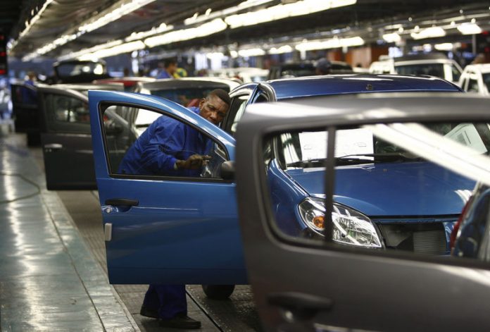 A worker inspects cars at Nissan's manufacturing plant in Rosslyn