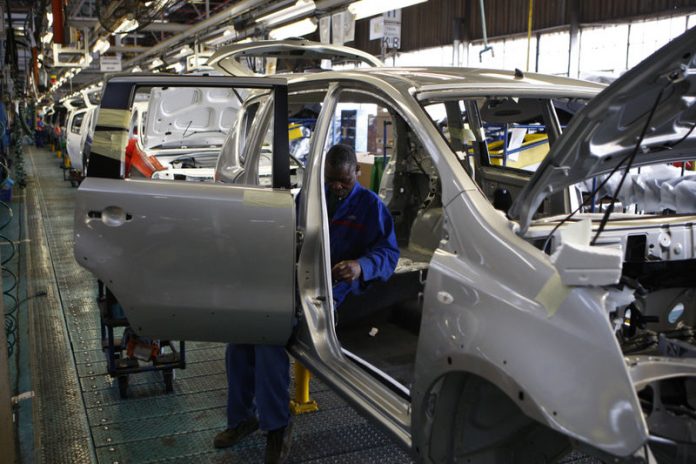 A worker assembles a car at a Nissan's manufacturing plant in Rosslyn