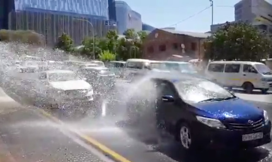 Screenshot of South African drivers turning a burst water pipe into a car wash!
