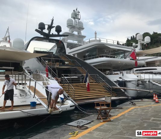 Deck hands working on yachts in Portofino, Italy