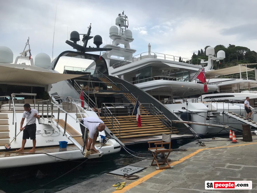 Deck hands working on yachts in Portofino, Italy