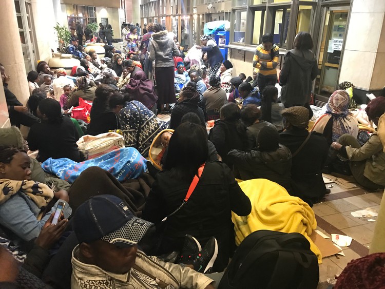 Refugees sit outside the UNHCR offices in Cape Town South Africa