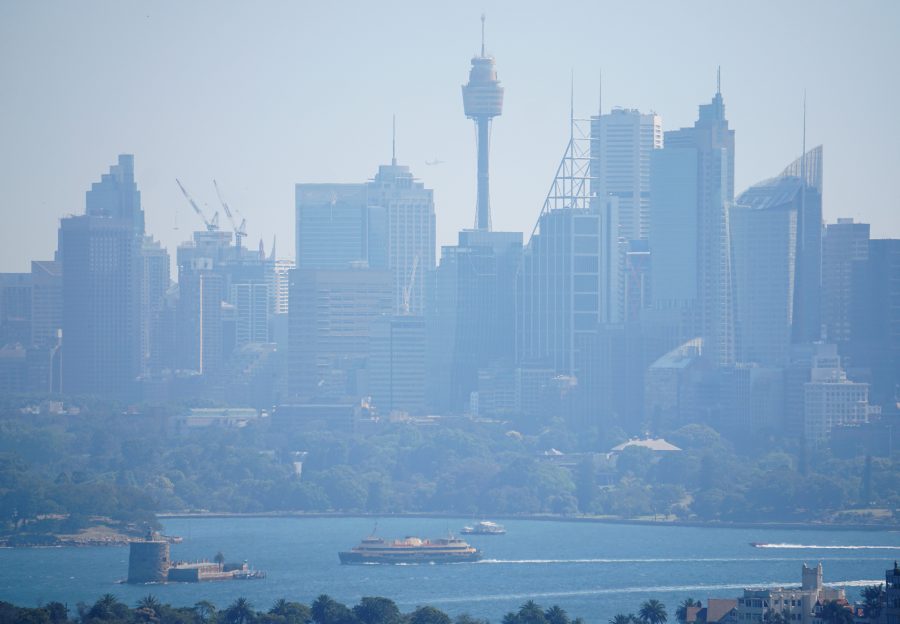 A ferry passes in front of the Central Business District as smoke from bushfires shroud Sydney