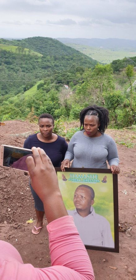 The two angry women Thobeko Mhlongo (left) and Thandaza Mtshali (right).  Thandaza is holding a pic of her deceased uncle Sifiso Justice Mhlongo who died aged 46 and was in the body bag taken by the two women to the Old Mutual office in Stanger, KwaZulu-Natal, South Africa.