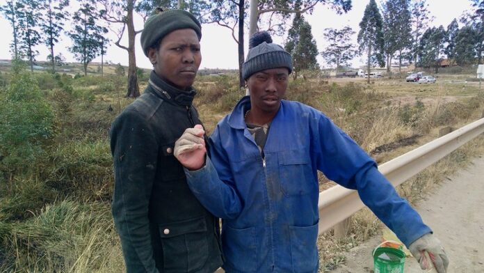“We decided to help the people of Lusikisiki and ourselves,” says Siphiwe Mlonji (right). He and Lindani Mbotyeni (left) fix potholes on the R61 to Flagstaff. Photo: Sibahle Siqathule