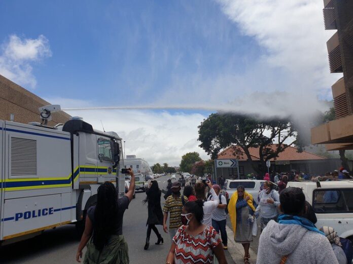 Hundreds of people queueing outside the SASSA offices in Bellville were doused with water by police after they were told to observe social distance on Friday. Photo: Mary-Anne Gontsana