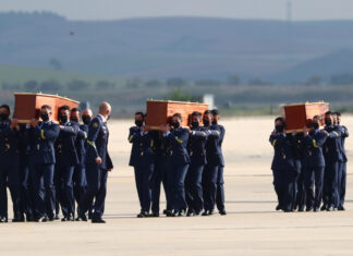 Spanish Air Force personnel carry coffins of two Spanish journalists and an Irish citizen who were killed in an armed ambush on an anti-poaching patrol in Burkina Faso, at the military airbase in Torrejon de Ardoz, Spain, April 30, 2021. REUTER/Sergio Perez
