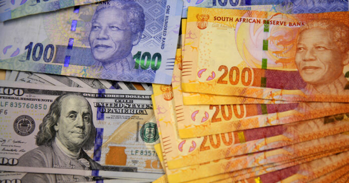South African bank notes featuring images of former South African President Nelson Mandela (R) are displayed next to the American dollar notes in this photo illustration in Johannesburg , file. REUTERS/Siphiwe Sibeko
