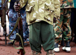 A former child soldier holds a gun as they participate in a child soldiers' release ceremony, outside Yambio, South Sudan, August 7, 2018. REUTERS/Andreea Campeanu