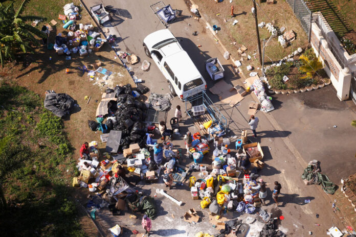 People loot an area near a burning warehouse in Durban People loot an area near a burning warehouse after violence erupted following the jailing of former South African President Jacob Zuma, in Durban, South Africa, July 14, 2021. REUTERS/Rogan Ward