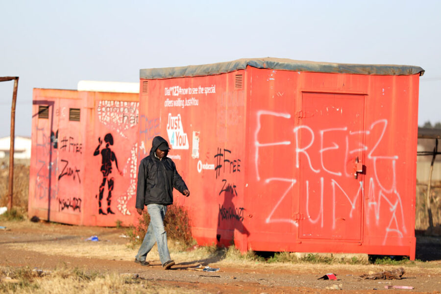 A man walks past a graffiti with the words "Free Zuma" as the country deploys army to quell unrest linked to the jailing of former South African President Jacob Zuma, in Vosloorus, South Africa, July 14, 2021. REUTERS/Siphiwe Sibeko