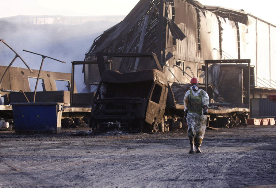 FILE PHOTO: A member of a hazardous waste cleanup crew walks to clean up a warehouse which was burned during days of looting following the imprisonment of former South African President Jacob Zuma, in Durban, South Africa, July 17, 2021. REUTERS/Rogan Ward TPX IMAGES OF THE DAY