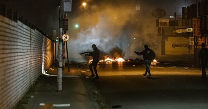 South-Africa-burning Private armed security officers take a position near a burning barricade during a joint operation with South African Police Service officers in Jeppestown, Johannesburg. Photo by Marco Longari/AFP via Getty Images