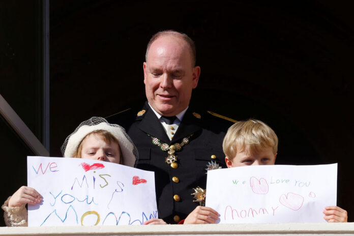 Prince Albert II of Monaco, Prince Jacques and Princess Gabriella holding message which read 