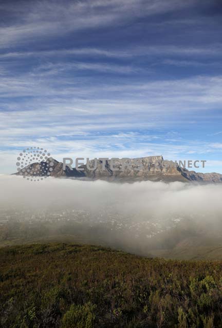 Seasonal fog disapates over the city beneath Table Mountain in Cape Town