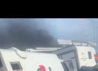 A looter with his arms full of looted cash clutching R10 (50p), R20 (£1), R50 (£2.50), R 100 (£5) and R200 (£10) notes scooped up from the motorway after robbers blew up an armoured cash track blowing money 100 feet up into the air