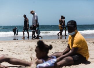 Holidaymakers relax on the South Beach during New Year festivities in Durban after the government lifted COVID-19 restrictions. Photo by Rajesh Jantilal/AFP via Getty Images