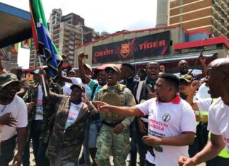 People attending an Operation Dudula protest wear branded T-shirts, which were on sale for R50. Nhlanhla Lux Dlamini, one of the group’s leaders, was among a handful of people wearing military-style clothing. Dlamini said they would not rest until South Africans were put first and given more opportunities. Photo: Masego Mafata