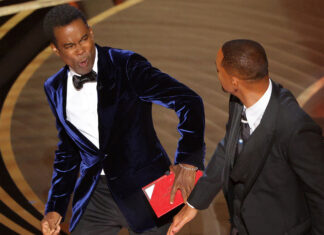 Will Smith (R) hits at Chris Rock as Rock spoke on stage during the 94th Academy Awards in Hollywood, Los Angeles, California, U.S., March 27, 2022. REUTERS/Brian Snyder