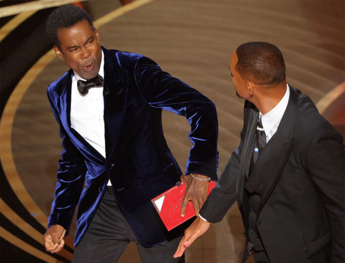 94th Academy Awards - Oscars Show - Hollywood Will Smith (R) hits at Chris Rock as Rock spoke on stage during the 94th Academy Awards in Hollywood, Los Angeles, California, U.S., March 27, 2022. REUTERS/Brian Snyder