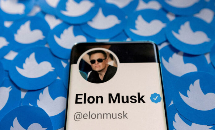 FILE PHOTO: Illustration shows Elon Musk's Twitter profile on smartphone and printed Twitter logos Elon Musk Puts $44-Billion Twitter Deal on Hold Over Fake Account Data