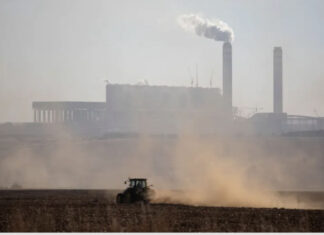 A farmer works with his tractor in front of the Kusile Power Station located in eMalahleni. In Gauteng province residents can sometimes smell the pollution coming from this direction. Wikus de Wet/AFP via Getty Images