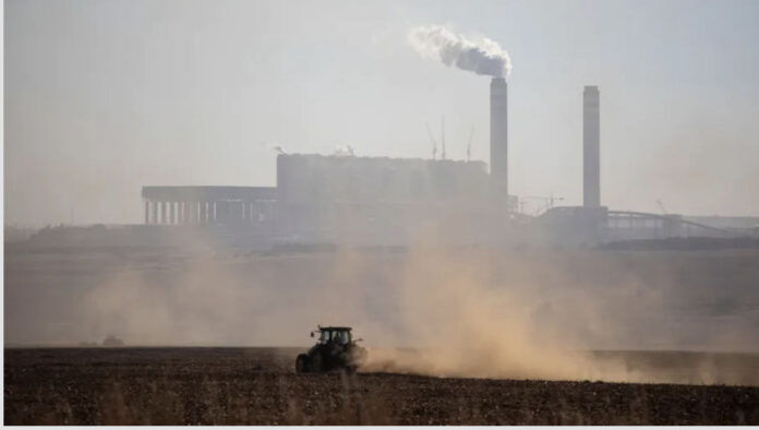 A farmer works with his tractor in front of the Kusile Power Station located in eMalahleni. In Gauteng province residents can sometimes smell the pollution coming from this direction. Wikus de Wet/AFP via Getty Images
