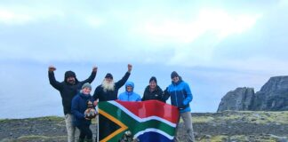 The Kingsley Holgate expedition team proudly flies the South African flag on the cliffs of Nordkapp in Norway at the culmination of their successful Hot Cape to Cold Cape transcontinental journey from Cape Agulhas.