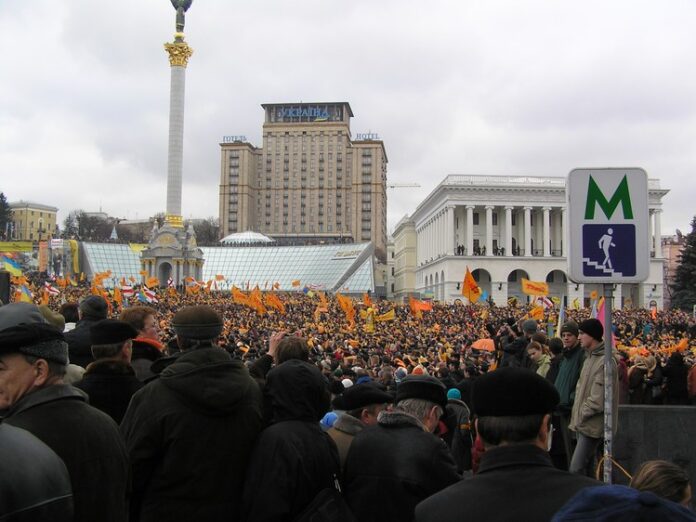 This photo was taken on the morning of the first day of the Orange Revolution in 2004. Ukrainians protested against an election mired in corruption. A new free and fair election was subsequently held. Russia has consistently undermined Ukrainian democracy, but the Ukrainian people have stood up for their rights. Photo: Wikimedia user Serhiy (CC BY-SA 3.0)